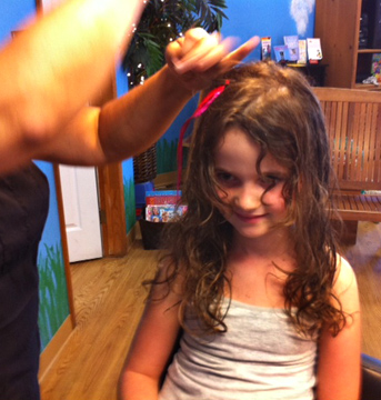 Photo of hair feather being put in girl's hair