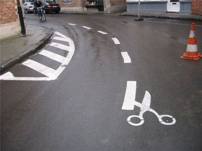 Photo of street art scissors cutting street
