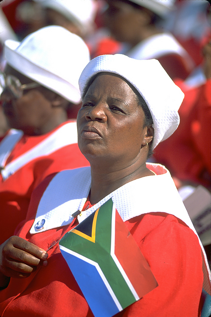 Photo of South African woman holding the new flag at a rally for Nelson Mandela